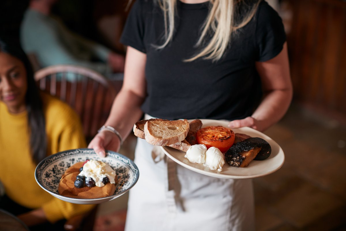 En person serverar mat på en restaurang